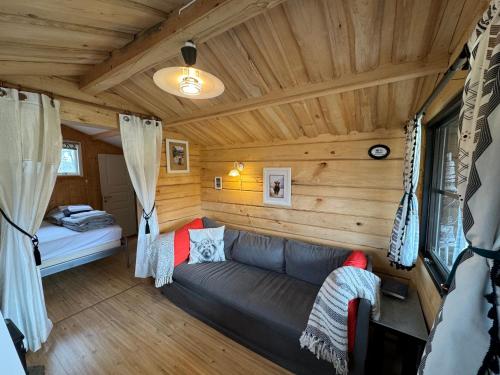 a living room with a couch in a log cabin at The Hideout Log Cabin- 2km to Klarälvsbanan and swimming area in Munkfors