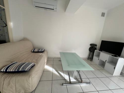 - un salon avec un canapé et une table dans l'établissement T1 bas de villa, à Ollioules
