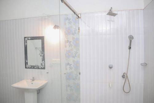 a bathroom with a shower and a sink at For Backpackers -Close to the National Park- in Udawalawe