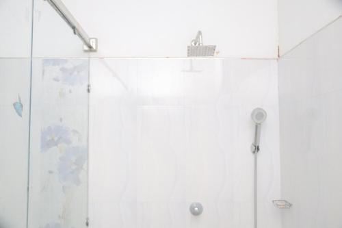 a shower with a glass door in a bathroom at For Backpackers -Close to the National Park- in Udawalawe