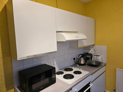 a kitchen with a microwave and a stove top oven at Luxury Home in Lewisham in Bromley