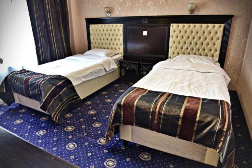 two beds sitting next to each other in a room at Ambasador in Valea Lupului