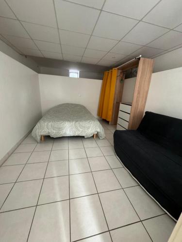 een kleine slaapkamer met een bed en een tegelvloer bij T1 bas de villa in Ollioules