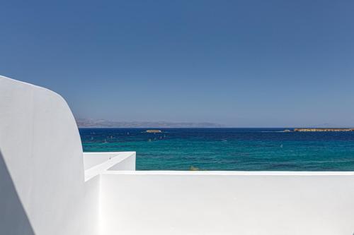 a view of the ocean from a white railing at Paros Blue Dolphin FULLY RENOVATED by RIVEA GROUP in Chrissi Akti