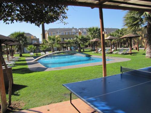 a view of a swimming pool in a park at Apart Hotel Gran Pacifico in La Serena