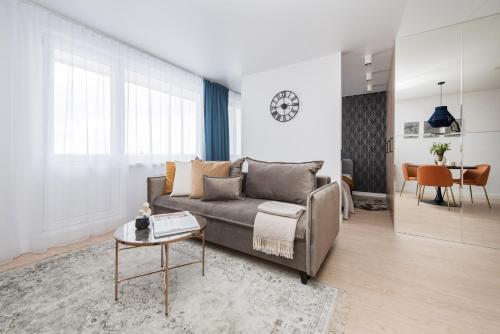 uma sala de estar com um sofá e uma mesa em Near Gates of Dawn / Modern 1 bedroom / w/Netflix em Vilnius