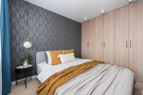 um quarto com uma cama e uma parede em Near Gates of Dawn / Modern 1 bedroom / w/Netflix em Vilnius