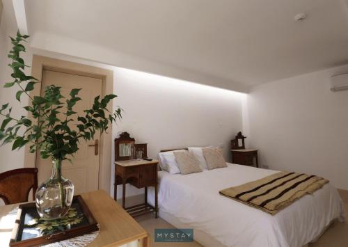 a bedroom with a bed and a vase on a table at MyStay - Casa Matriz Séc XVI in Penafiel