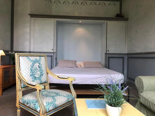 a bedroom with a bed and a chair and a couch at Le Domaine du Château des Gipières By Ateya Vacances in Montbrun-les-Bains