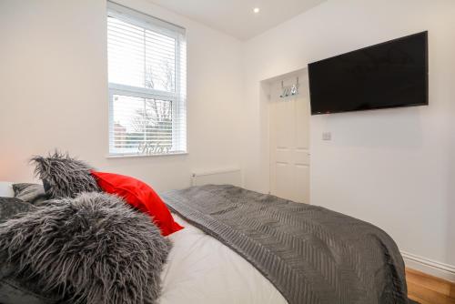 Schlafzimmer mit einem Bett und einem Flachbild-TV in der Unterkunft Henry Court Apartment 3 in York