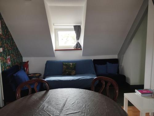 a living room with a blue couch and a table at L'Albatros in Perros-Guirec