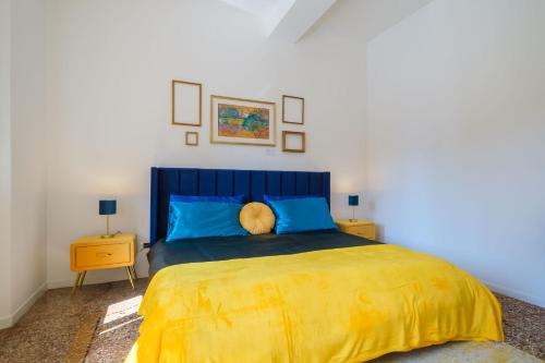 - une chambre dotée d'un grand lit avec des draps bleus et jaunes dans l'établissement Residenza Bellavista Design e Vista Mozzafiato, à Bologne