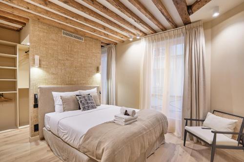 une chambre avec un grand lit blanc et une fenêtre dans l'établissement Appartement au coeur de Paris Madeleine by Studio prestige, à Paris
