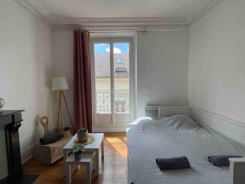 sypialnia z łóżkiem i dużym oknem w obiekcie R'Apparts T2 Le Chaleureux - Hypercentre - Gare w Grenoble