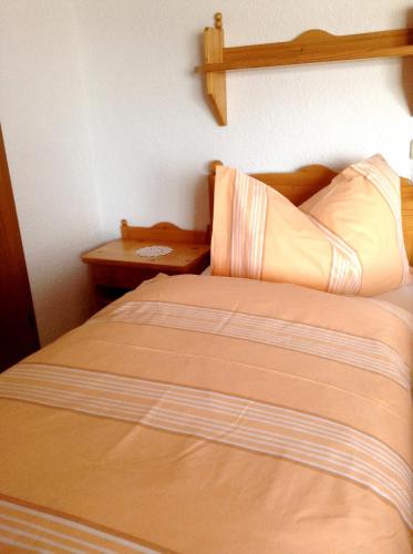 a bed in a bedroom with a wooden head board at Ferienhof Kriechbaumer in Schönau im Mühlkreis