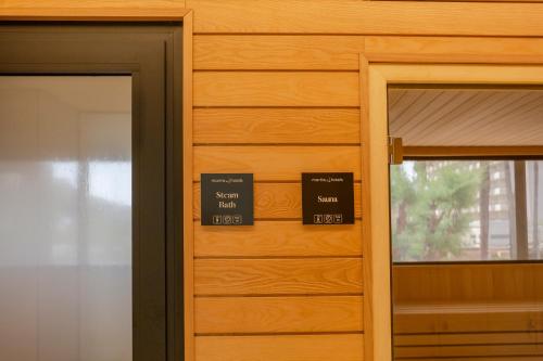 two signs on a wooden door in a room at Marins Playa in Cala Millor
