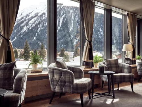 Precise Tale Seehof Davos في دافوس: غرفة مع نافذة كبيرة مع كراسي وطاولة