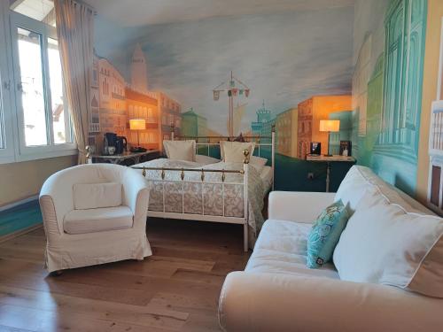 a bedroom with a bed and a couch and chairs at PARK VILLA zentral am Mittelrhein in Boppard