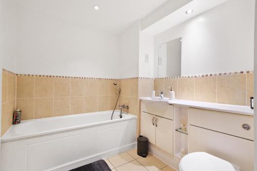 a bathroom with a tub and a toilet and a sink at Central Bishops Stortford 2BR Apartment in Bishops Stortford