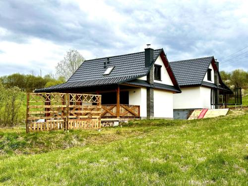 una gran casa blanca con techo negro en Przystanek Przylasek, en Grywałd