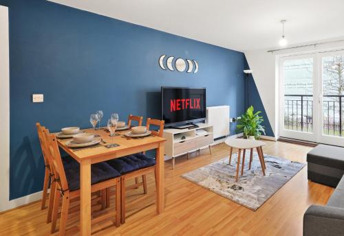 una sala da pranzo con un tavolo e una tv di 2BR Apartment Central Bishops Stortford a Bishops Stortford