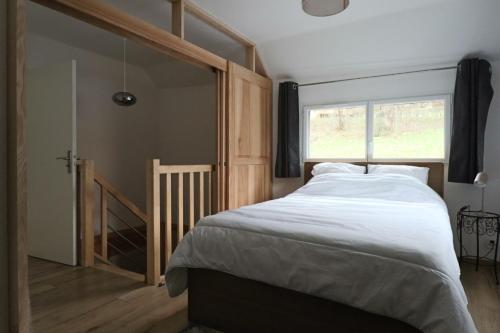 sypialnia z dużym łóżkiem i oknem w obiekcie La Petite Montille w mieście Mont-Dore