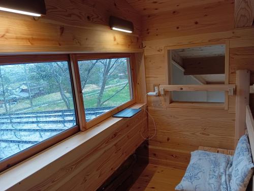 um quarto com uma janela num chalé de madeira em 青い空と白い龍 em Minami Aso