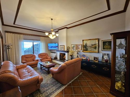 a living room with a couch and chairs and a tv at Vila DANI near Castle and Old Bazar in Krujë