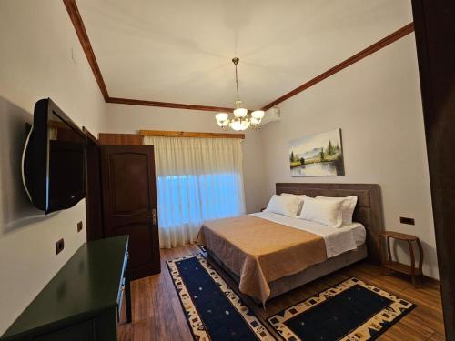a bedroom with a bed and a flat screen tv at Vila DANI near Castle and Old Bazar in Krujë
