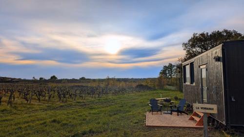 una casita en un campo con mesa y sillas en Tiny House au milieu des Vignes en Arbis