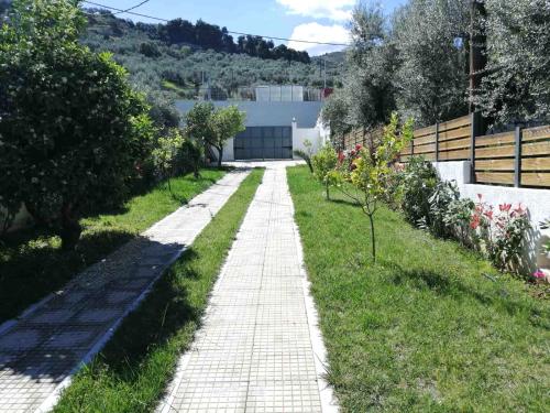a brick path in a garden with grass and flowers at Galini Studios Paralia Platanou in Akrata