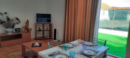 a living room with a table and a window at Casa do Meio in Lamas