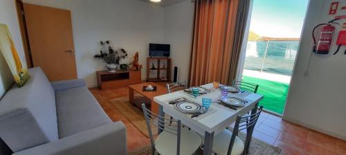 a living room with a white table and a couch at Casa do Meio in Lamas