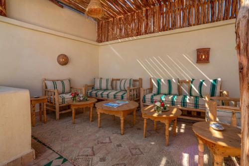 una sala de estar con sofás y mesas. en Riad Chez Henriette en Marrakech