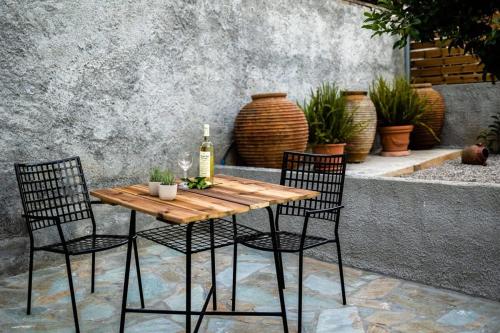 a table with two chairs and a bottle of wine at Valira Cozy Maisonette - Relaxing Vibes Getaway in Valíra