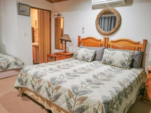 1 dormitorio con 1 cama grande y espejo en Seaviews Holiday Resort, en Jeffreys Bay