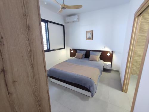 a bedroom with a bed and a ceiling fan at Lodge Tamarins in Saint-Pierre