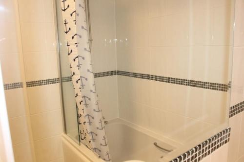 a bathroom with a tub and a shower curtain at Sparrows, Wangford nr Southwold in Wangford