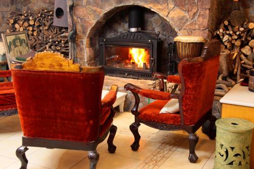 a living room with two chairs and a fireplace at La Maison du Laoshay Lijiang in Lijiang