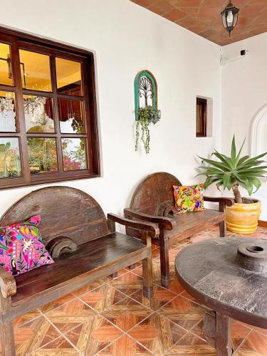 a room with two wooden benches and a table at Casa Balam Bed & Breakfast Boutique in Ciudad Vieja