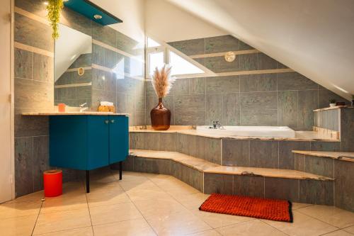 a bathroom with a blue cabinet and a bath tub at Villa Paola - Piscine, billard - Au Nord de l'île in Sainte-Marie
