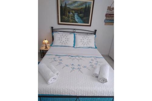 um quarto com uma cama com lençóis brancos e almofadas em Olga Studios em Heraclião