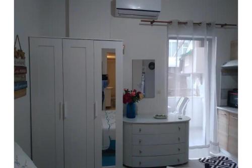 um quarto com um armário branco e uma janela em Olga Studios em Heraclião