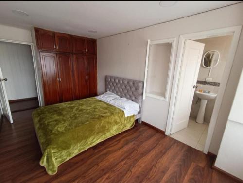 1 dormitorio con 1 cama y baño con lavamanos en Departamento Gigante de 4 dormitorios. Ecualodge 23, en Cuenca