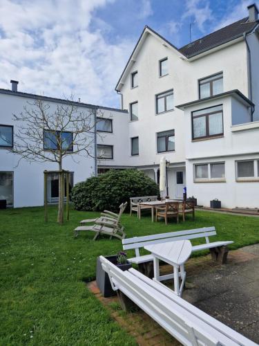 einer Gruppe von Bänken vor einem Gebäude in der Unterkunft Hotel Meeresfriede in Cuxhaven