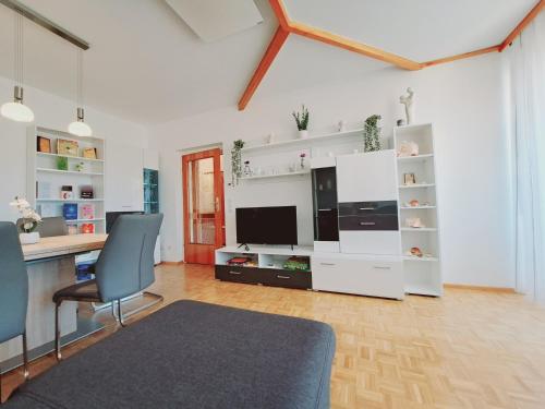 een woonkamer met een bureau en een tafel met stoelen bij Ferienwohnung nähe Redbull Ring in Judenburg