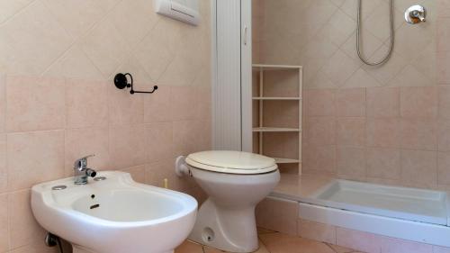 a bathroom with a toilet and a sink and a tub at Casa dei Lidi in Budoni