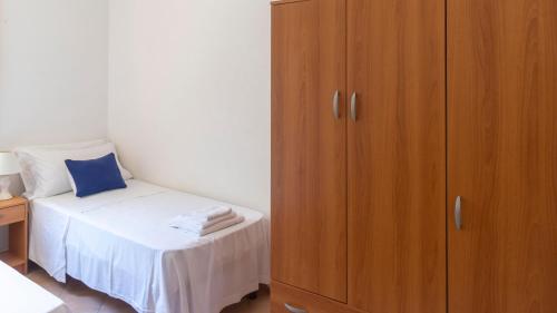 a bedroom with a bed next to a wooden cabinet at Casa dei Lidi in Budoni