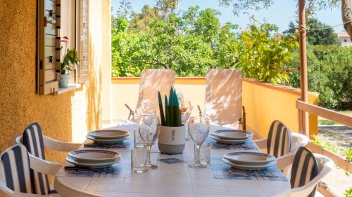 a table with plates and glasses on a table on a balcony at Casa dei Lidi in Budoni