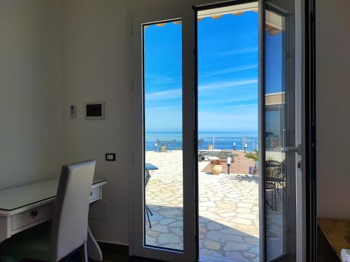 a sliding glass door with a view of the beach at Hotel Antica Cascina Del Golfo in Scopello